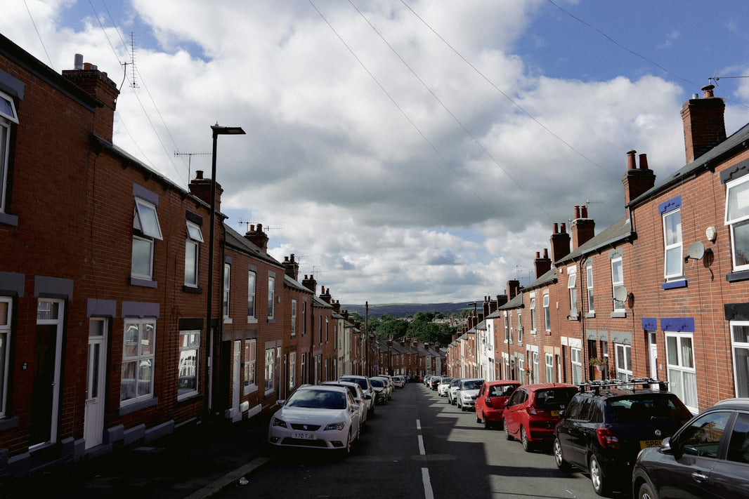 cars parked on the side of a street next to brick buildings
