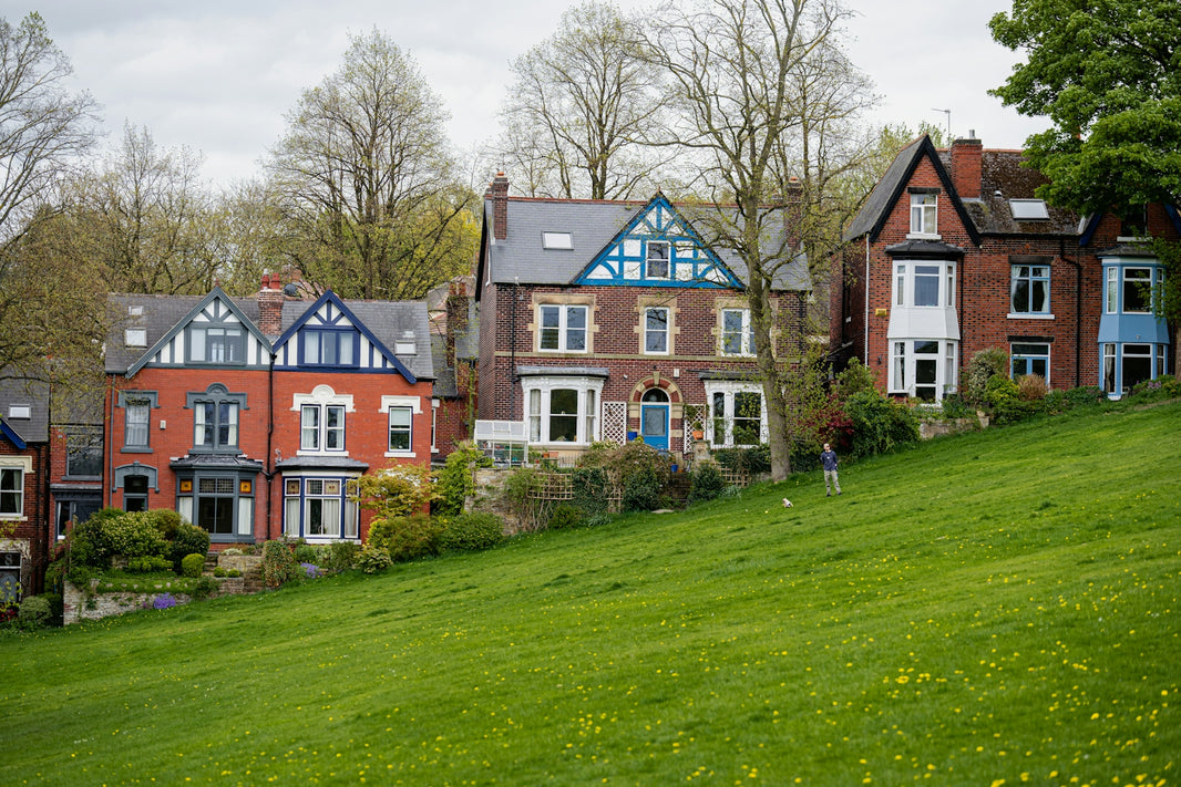 a row of houses sitting on top of a lush green hillside