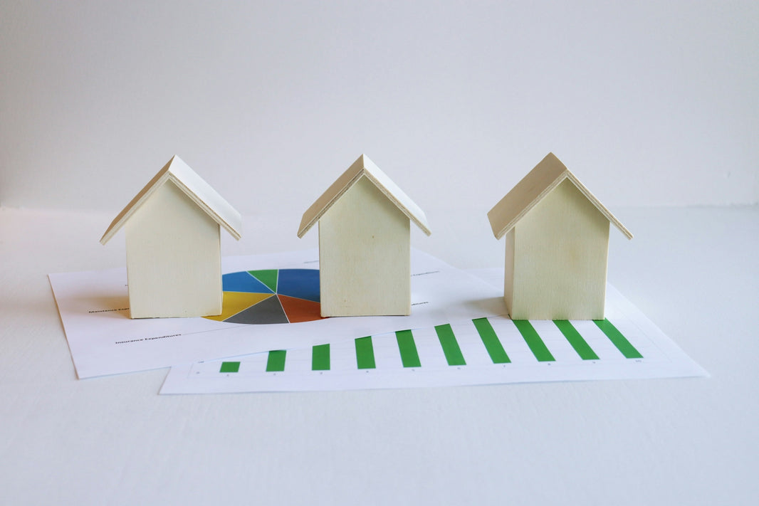 three small houses sitting on top of a piece of paper
