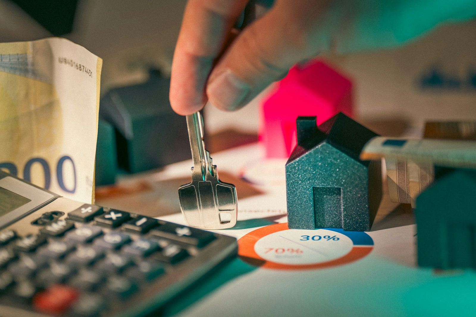 hand holding key over house models
