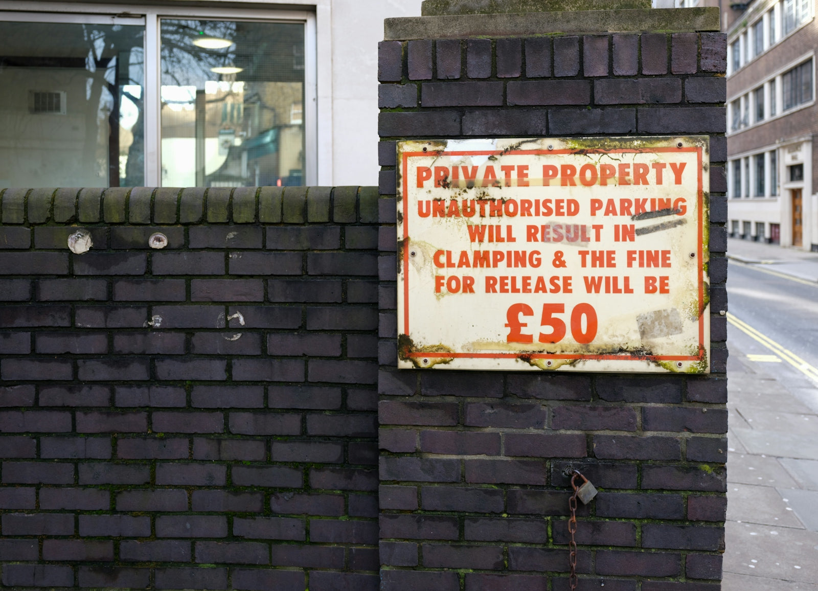 Private property sign with parking fine information.