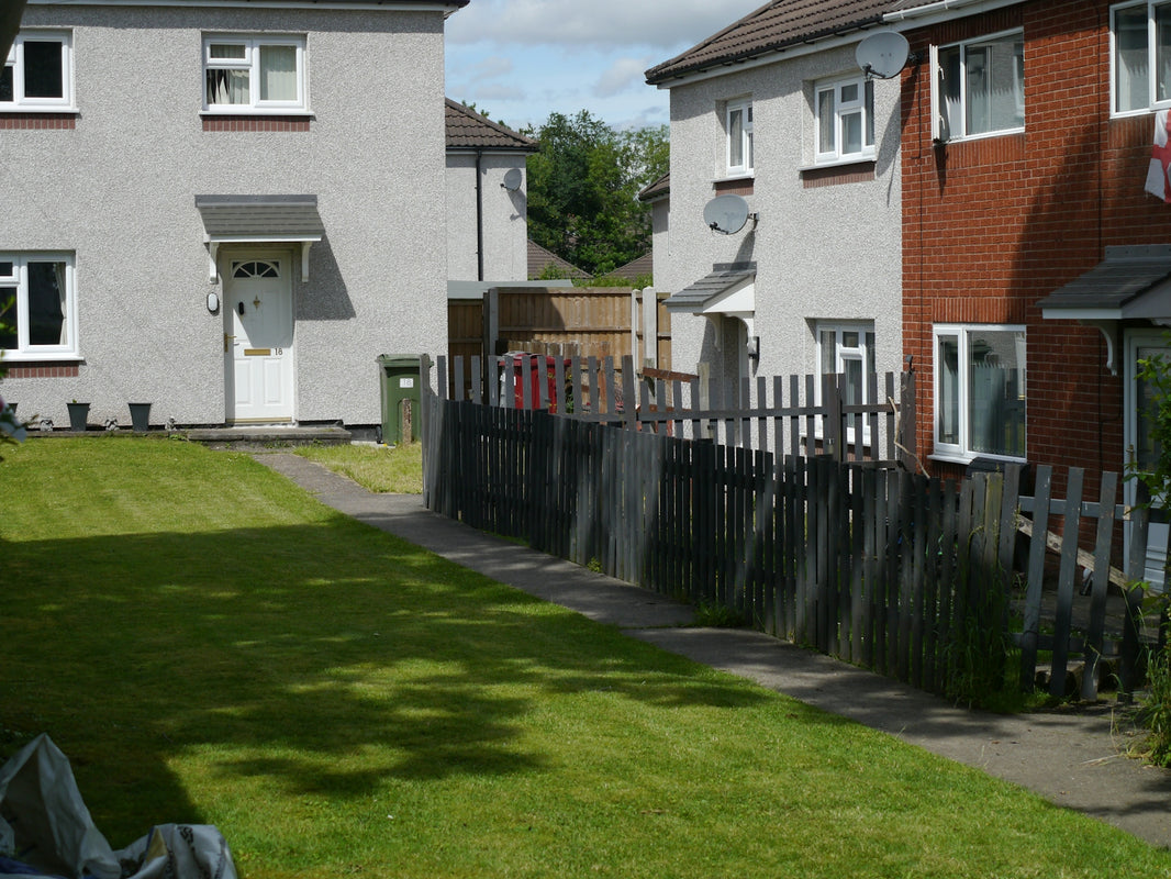 Residential houses with green lawn and wooden fence.